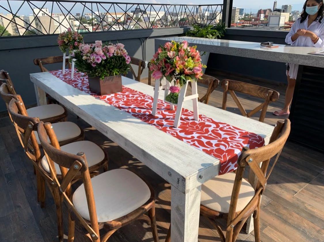 Mesa rústica con centros de flores en terraza