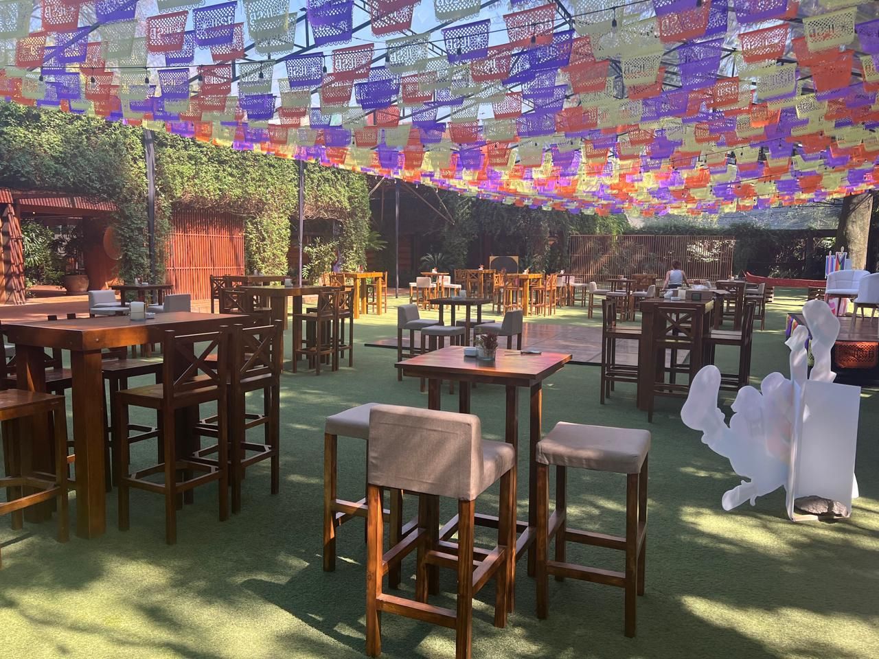 Jardín con papel picado y periqueras de madera